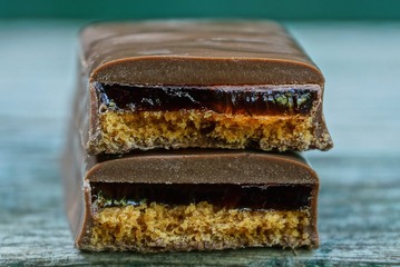 two pieces of brown chocolate bar lying on a gray table