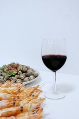 Blurred image of steamed shrimp, steamed cockles in white plate and wine on white table, set of dinner, Vertical, Copy space