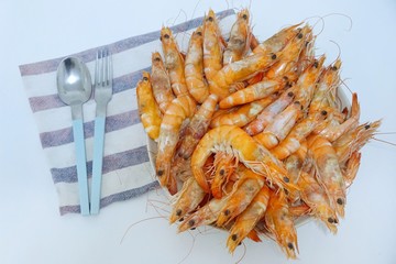 Blurred image of steamed shrimp in white plate on white table ready to eat, set of dinner