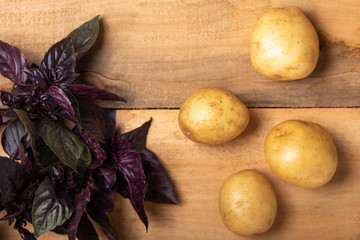 Raw fresh potatoes on a wooden surface