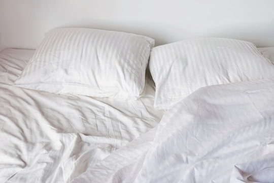 Messy Bed With White Pillows And Sheets