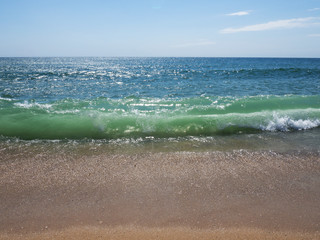 Waves on a sunny beach without objects and people. Copy space.