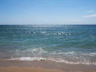 Waves on a sunny beach without objects and people.