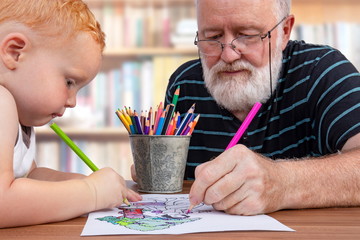 Teamwork between grandfather and grandson to color a drawing