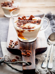 Joghurt mit Honig und Granola in einem Glas, rustikaler Stil, gesundes Frühstück
