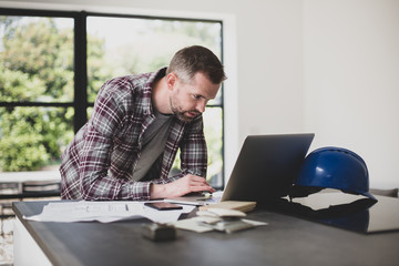 Contractor using laptop in home development