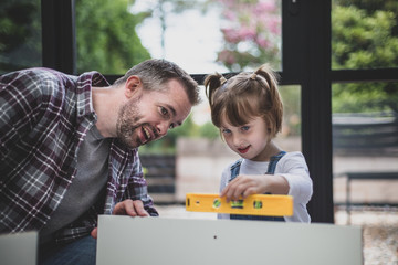Father teaching Daughter how to use a spirit level