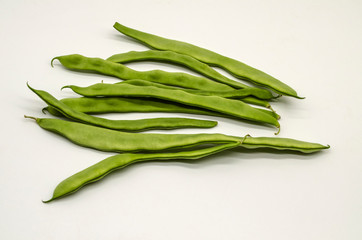 Prepared for use in cooking, immature tender green bean pods on white background
