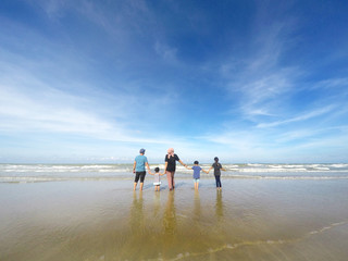 rear view of family with three children standing over beautiful blue sky. Concept of family, happiness, parenting and relationship