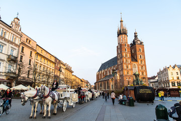 Naklejka na ściany i meble Krakow, Poland - April, 2019: Church of St. Mary and the Cloth Hall on the main market square in Krakow