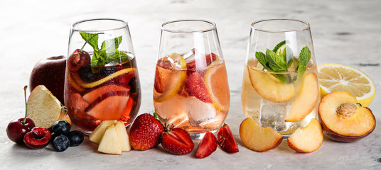 Selection of sangrias - red, pink, white and ingredients, rustic background