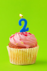 Delicious cupcakes with candles on a colored background. Festive background, birthday