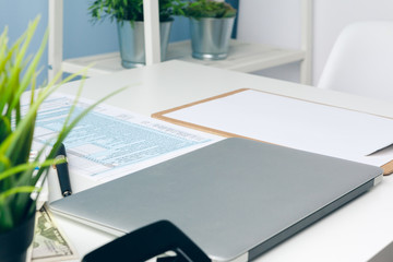 paperwork in the office and laptop on the desktop