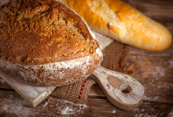 Whole grain home baked bread on rustic wooden background