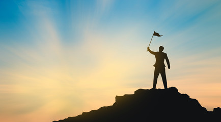 silhouette of man on mountain top over sky and sun light background,business, success, leadership,...