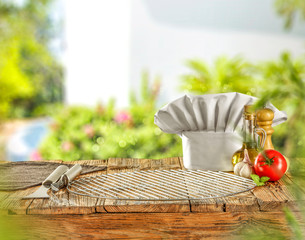 Desk of free space and grill time and cook hat. Summer garden background.