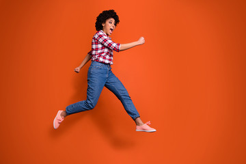 Fototapeta na wymiar Full body side photo of excited jumping high lady yelling loud sale discount shopping wear casual clothes outfit isolated orange background