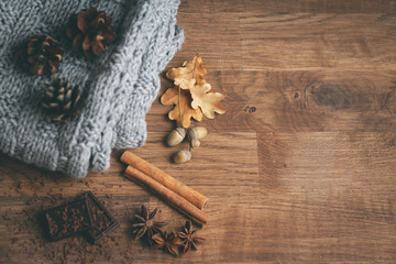 Autumn composition. Gift, autumn leaves, cinnamon sticks, anise stars, pine cones on wood background. Flat lay, top view, copy space. Toned cold time background