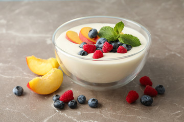 Bowl with sour cream yogurt and fruits on grey background