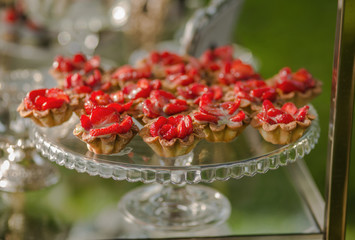 Delicious cakes with cream and strawberries, cooked for birthday and wedding on a large glass tray.