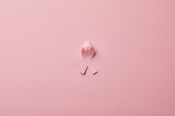 breast cancer ribbon on light pink background
