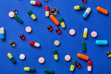 top view of different medical pills on blue background