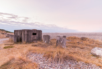 WW2 coastal beach defences with concrete anti tank blocks and a pillbox