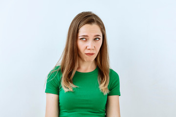 Fototapeta premium Skeptic and mistrust emotion. Young girl portrait against white background