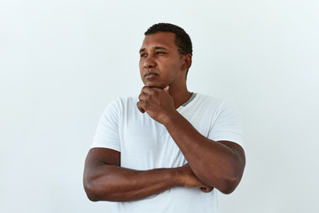  Thoughtful, thinking emotion concept. African American man touch him chin and think about something,portrait on white backgound.