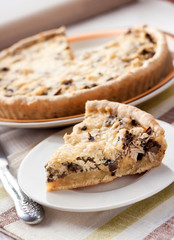 Slice of chicken tart with mushrooms and cheese on a plate