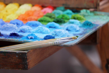 Brushes and palette with multi-colored paints. Concept of the artist studio, painting and creativity