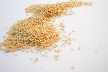 grains de riz  complet en vrac sur fond blanc 