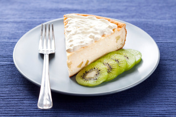 Homemade cottage cheese and semolina cake with kiwi fruit and cream on a plate