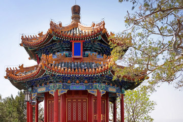 Colorful building inside the Palace Museum, known also as the Forbidden City in Beijing, China, surrounded by green vegetation.