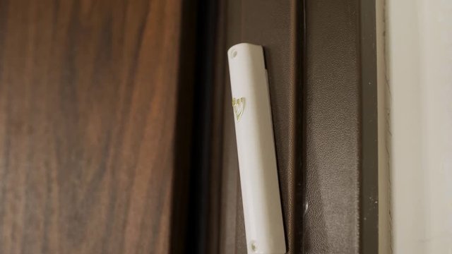 Tilt up revealing a Jewish Mezuzah set on the door