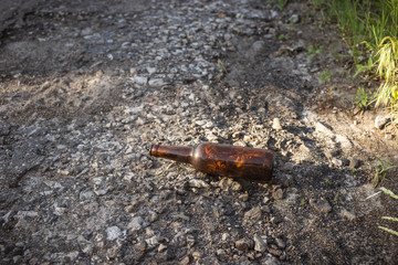 Brown beer bottle by the road.