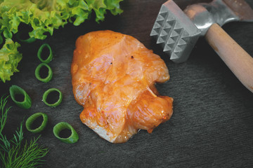 Slice of pickled turkey fillet on a kitchen cutting board background.