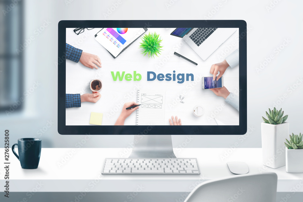 Poster Web design studio concept. Desktop computer display on flat office desk. Close-up.