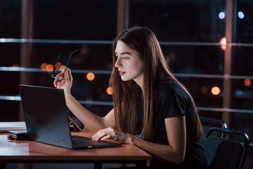 Beautiful blonde businesswoman works alone in the office at nightime