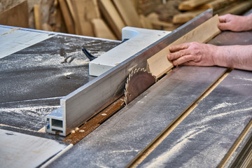 Crop craftsman cutting wood with table saw
