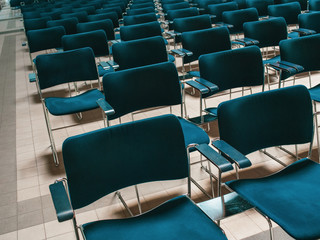 Rows of blue chairs in the conference hall, audience
