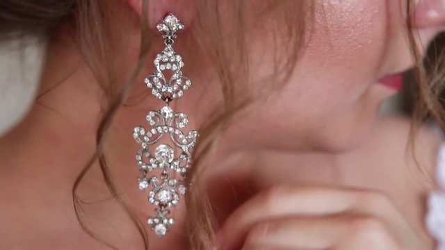 wedding earrings on female hand she takes earrings bride