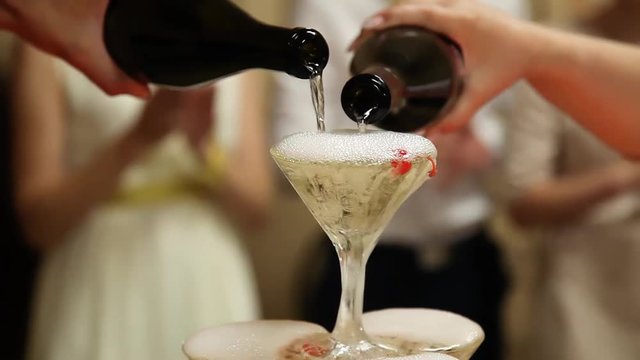 Filling glasses with champagne. pyramid of champagne glasses. bartender Shaw