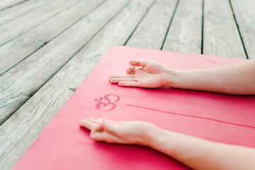 Hands on a yoga mat with an om mantra symbol