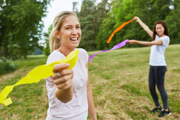 Junge Frauen spielen mit bunten Bändern