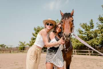 women in a countryside walking with a horse