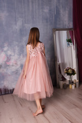Naklejka premium a girl in a romantic dress is dancing in the room with mirror