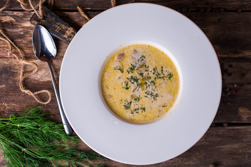 Tasty onion soup with fresh green on rustic wooden table