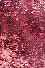 Sequins background. Background with shiny sequins on fabric. Abstract texture scales with pink sequins