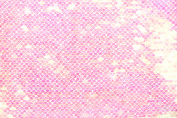 Sequins background. Background with shiny sequins on fabric. Abstract texture scales with pink...